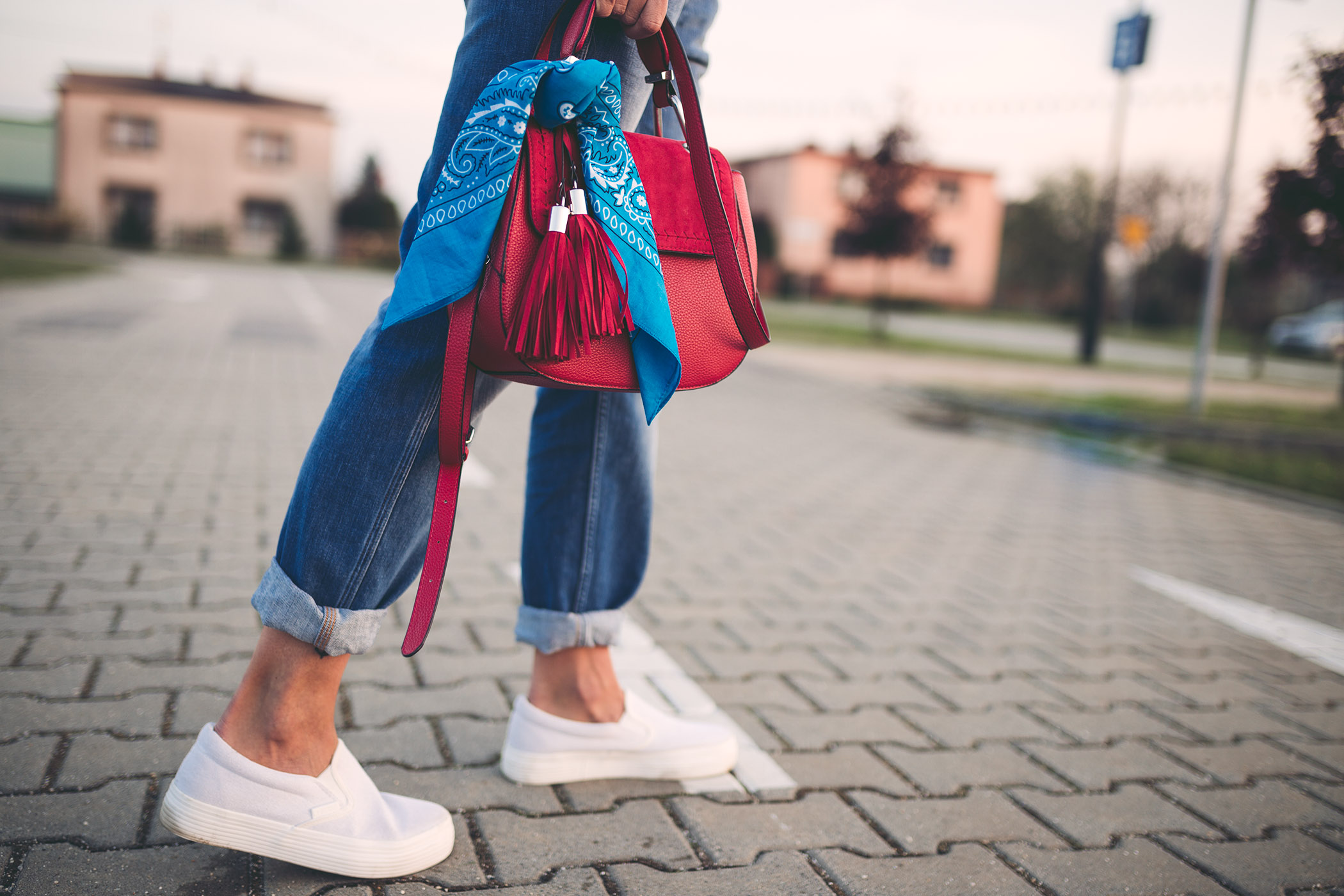Wygodne białe trampki i dżinsowe ogrodniczki z podwiniętymi nogawkami