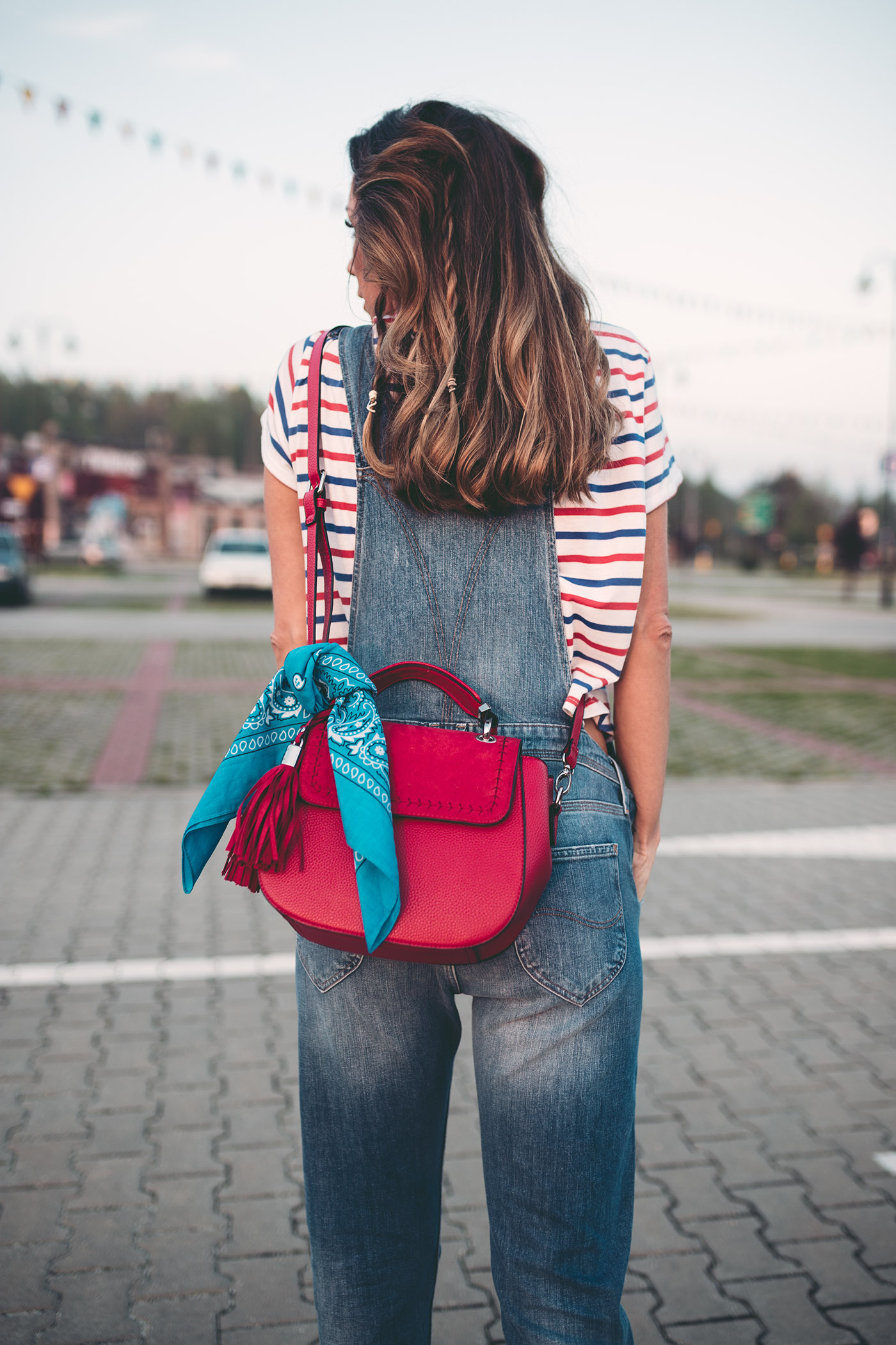 Czerwona torebka przewiązana błękitną chustką