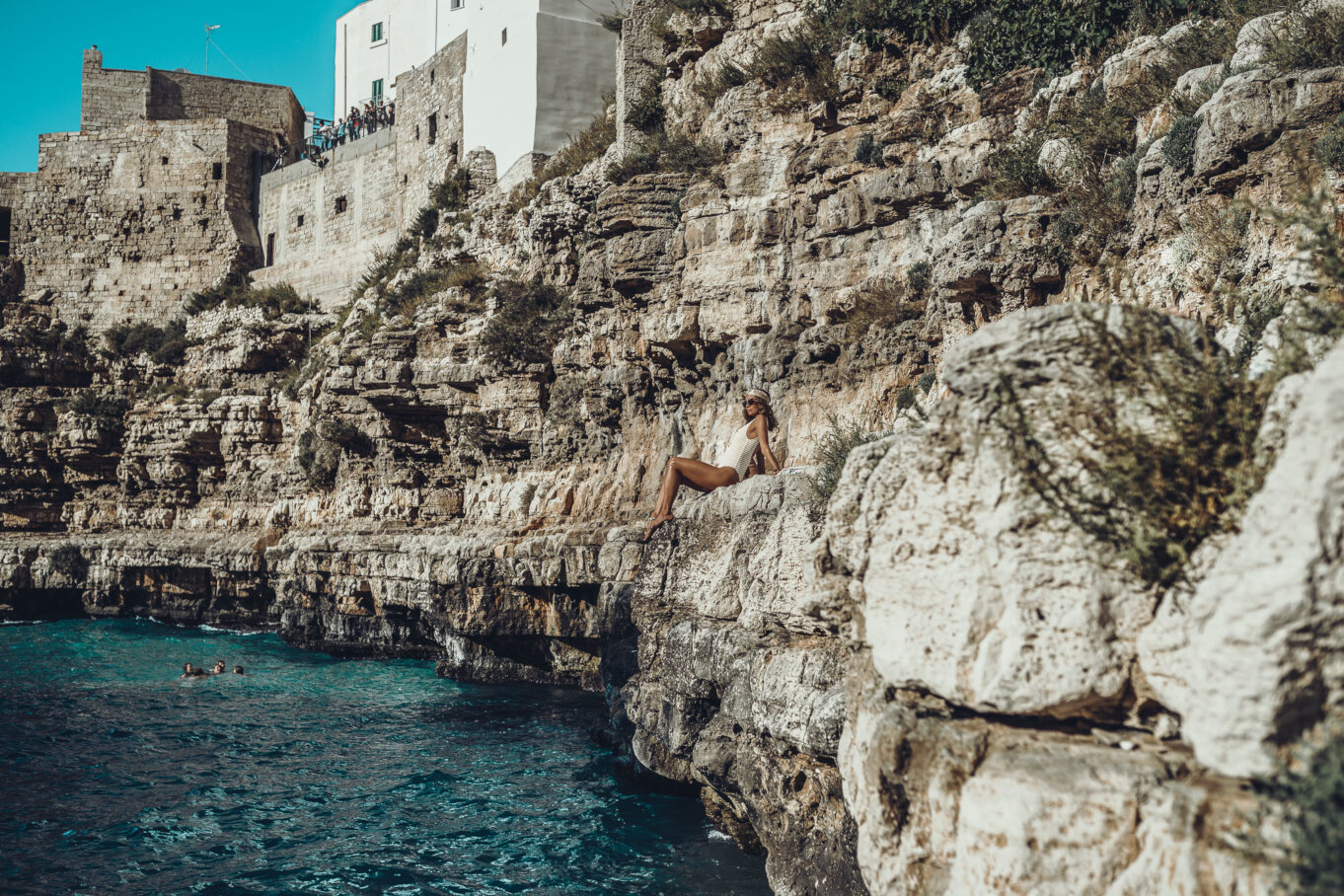 Opalanie na skalistym brzegu plaży w Polignano a Mare