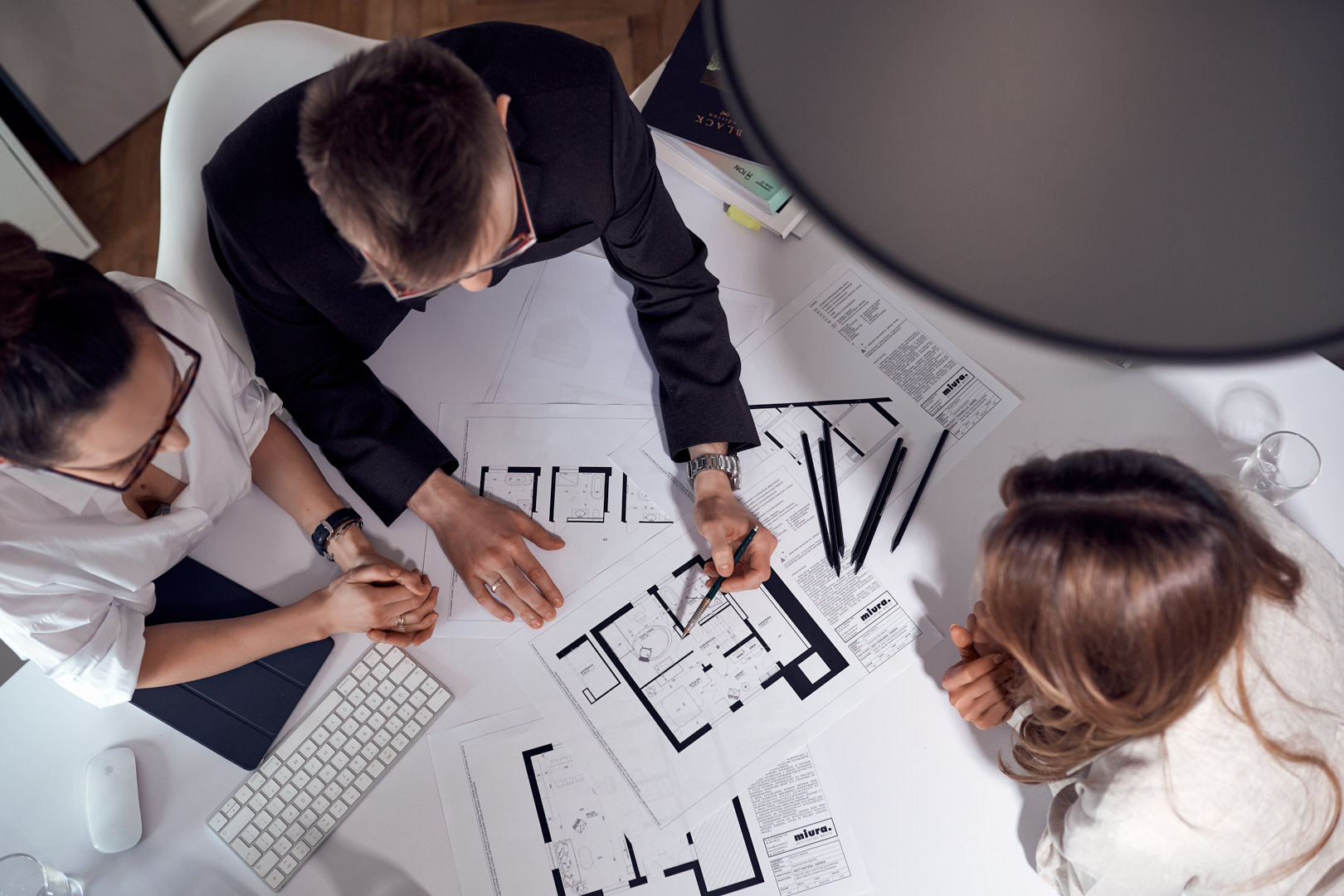 Architekci wnętrz omawiają rzut projektu domu jednorodzinnego